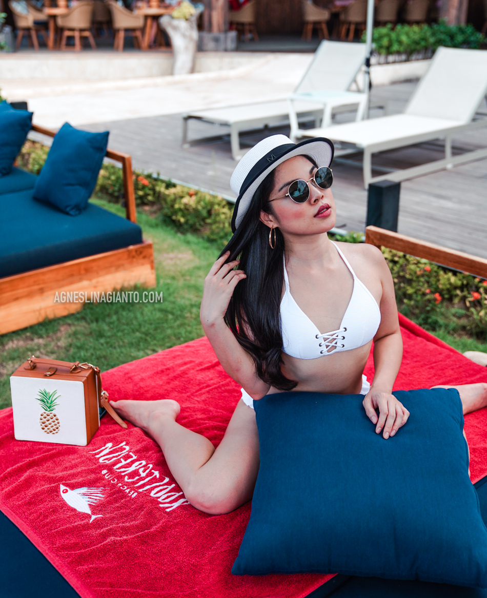 Girl on daybed at a beach club in Bali, Roosterfish Beach Club